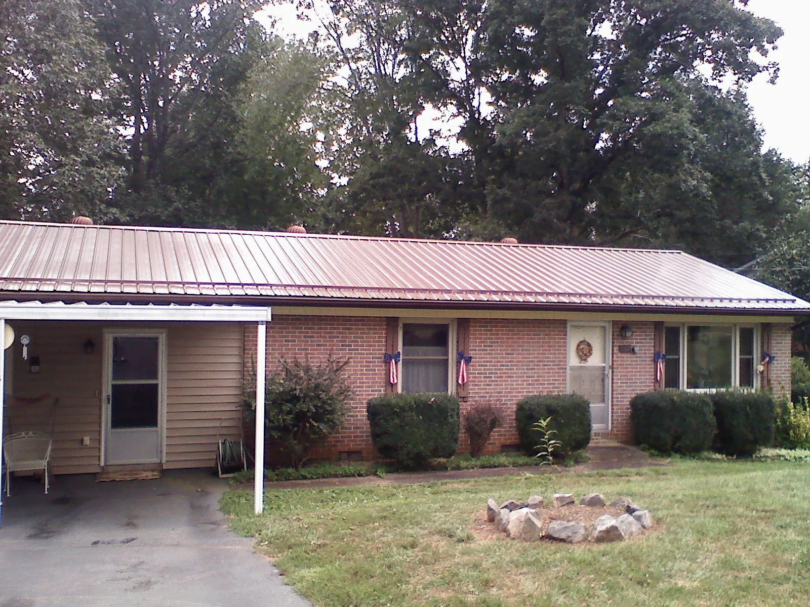 Bronze metal roof and carport on a brick ranch home — Roof Repair work by our crew in New Hartford